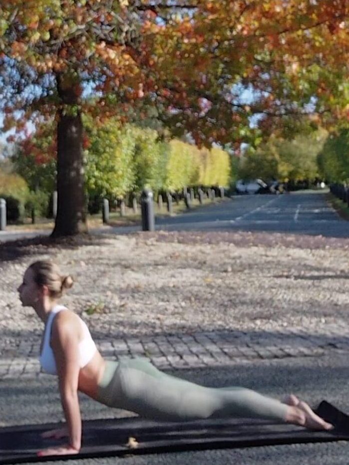 Yoga London private class with UlaTrains, student practising gentle forward fold on mat